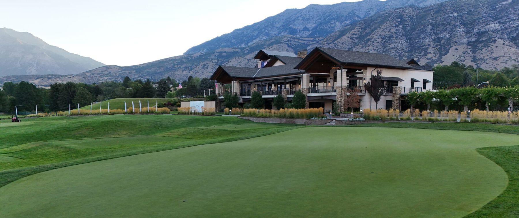 The Riverside clubhouse and putting green with the mountains behind